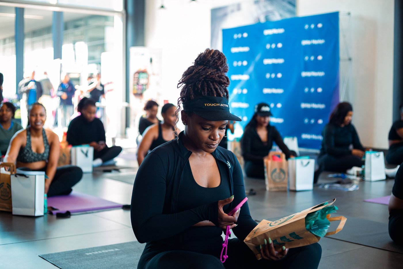 Guests seated on exercise mats at a BMW Menlyn wellness event